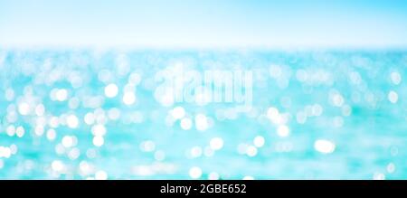 Defokussierte Meerwasseroberfläche glitzert auf der Sonne. Stockfoto