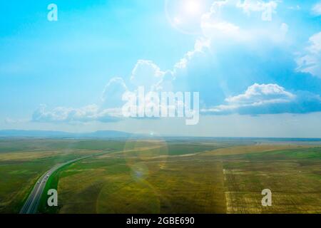 Luftaufnahme der Kertsch-Sewastopol Autobahn zwischen den Feldern vor dem Hintergrund der Berge, Krim. Stockfoto