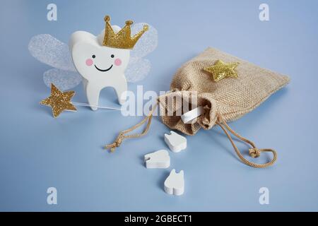 Nationaler Tag Der Zahnfee. Kinder haben eine Fee. Niedlicher Zahn mit Flügeln, einer Krone und einem Zauberstab und einer Tasche mit Zähnen. Stockfoto