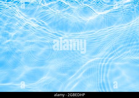 Oberfläche von Licht auf blauem transparentem Schwimmbadwasser. Trendy abstrakt gewellten Hintergrund. Wasser Wellen im Sonnenlicht mit Kopierraum. Stockfoto