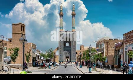 Yazd, Iran - Mai 2019: Einheimische und Touristen rund um das Tor und Minarette der Jameh Moschee von Yazd Stockfoto