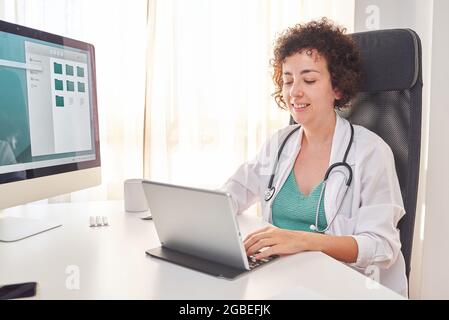 Eine Ärztin tippt auf ihren Laptop Stockfoto