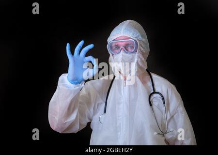 Ein Arzt in einem kovidierten Schutzanzug macht eine gute Geste Stockfoto