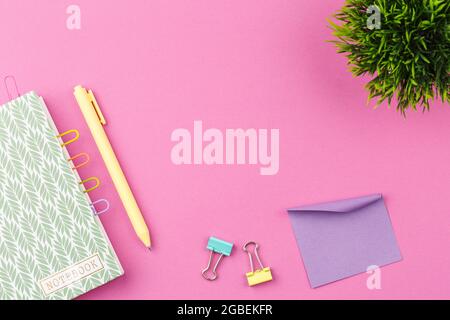 Notizblock mit Stift auf rosa Hintergrund. Stockfoto