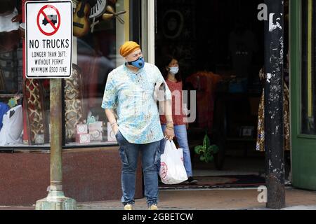 New Orleans, USA. August 2021. Menschen mit Gesichtsmasken werden am 3. August 2021 auf einer Straße in New Orleans, Louisiana, USA, gesehen. Der US-Gouverneur von Louisiana, John Bel Edwards, hat am Montag das landesweite Mandat für die Innenmaske wieder aufgenommen, da COVID-19-Fälle und Krankenhausaufenthalte weiter anstiegen. Nach dem Mandat, das vom 4. August bis mindestens 1. September in Kraft treten wird, müssen alle Menschen ab fünf Jahren an Innenräumen eine Gesichtsmaske tragen. Quelle: Lan Wei/Xinhua/Alamy Live News Stockfoto