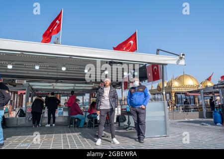 Eminonu, Istanbul, Türkei - 02.27.2021: Zwei Fischer posiert vor dem Fischrestaurant, das gegrillten Fisch auf dem Eminonu-Platz mit türkischem Fisch verkauft Stockfoto