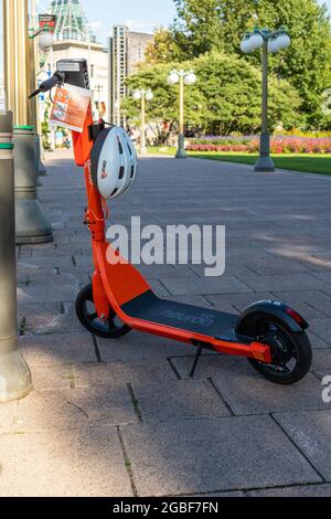 Ottawa, Kanada - 2. August 2021: Elektroroller mit Helm zur Miete auf der Straße. E-Scooter auf dem Bürgersteig in der Innenstadt Stockfoto