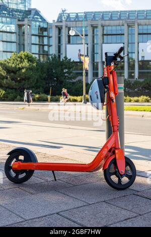 Ottawa, Kanada - 2. August 2021: Elektroroller mit Helm zur Miete auf der Straße. E-Scooter auf dem Bürgersteig in der Innenstadt Stockfoto