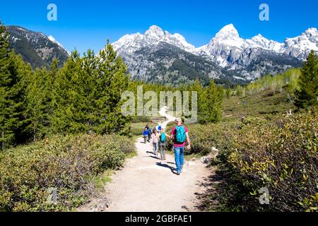 Grand Teton National Park, Jackson Hole, Wyoming, USA, Mai 31, 2021, Gruppe von Wanderern auf dem Weg vom Taggart Lake, horizontal Stockfoto