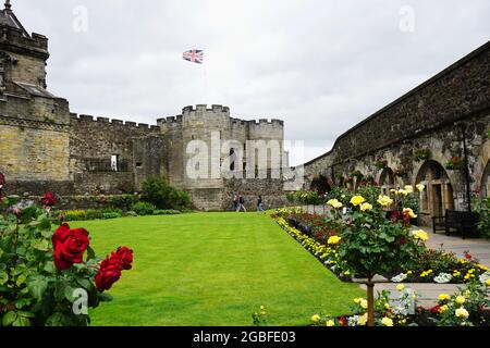 Blick über die eleganten Gärten, gefüllt mit blühenden Rosen, in Richtung The Forework, dem Haupteingang zum Stirling Castle, in Stirling, Schottland. Stockfoto