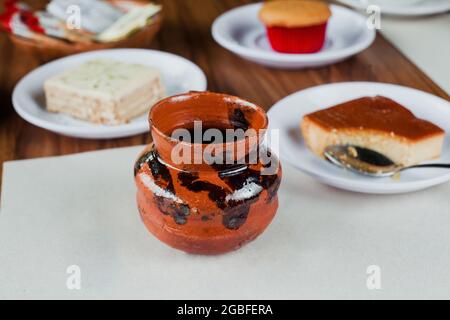 Jarrito oder Tonbecher mit Café de olla, traditioneller mexikanischer Kaffee und einige Desserts in Mexiko Stockfoto