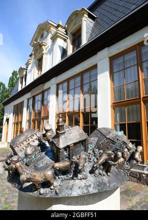 30. Juli 2021, Sachsen, Rötha/OT Mölbis: Vor der Orangerie im Schlosspark Mölbis steht die Bronzeskulptur 'Mölbis - Small World' des Künstlers Jürgen Raiber auf einem Sockel. Die Bronzeskulptur und eine neu errichtete Pergola sind Teil der Projekte der Dorfentwicklungsgesellschaft, die den Schlosspark im Zentrum des Dorfes mit Kunstwerken und barocken Elementen auf seine frühere Schönheit umgestalten will. Mölbis wurde in der DDR als das "dreckigste Dorf Europas" bekannt, weil die Umweltverschmutzung durch das Espenhain-Werk, das aus einer Schmelzerei, einer Kohlefazze, bestand Stockfoto