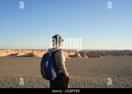 asiatische Backpacker-Frau, die die Yardang-Landform in der wüste gobi betrachtet Stockfoto