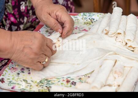 Hausfrau, die Käse in Yufka legt, macht traditionelle türkische sigara Boregi (Zigarette borek). Stockfoto