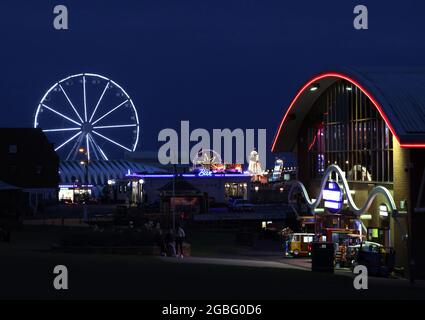 Hunstanton, Großbritannien. August 2021. Die Nachtlichter von Hunstanton vom Green aus gesehen und das View-Riesenrad, die Pier-Vergnügungen und die Messe Big Wheel und Helter Skelter, in Hunstanton, Norfolk, Großbritannien, am 2. August, 2021 Kredit: Paul Marriott/Alamy Live Nachrichten Stockfoto