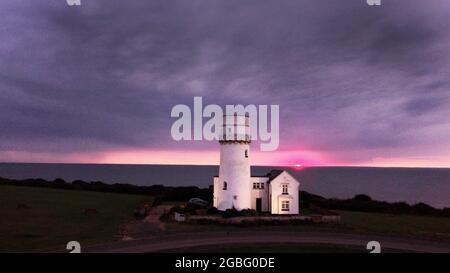 Hunstanton, Großbritannien. August 2021. Am 2. August 2021 geht die Sonne hinter dem alten Leuchtturm von Hunstanton am Ende der Tageslichtstunden in Hunstanton, Norfolk, Großbritannien, unter. Quelle: Paul Marriott/Alamy Live News Stockfoto