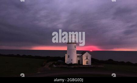 Hunstanton, Großbritannien. August 2021. Am 2. August 2021 geht die Sonne hinter dem alten Leuchtturm von Hunstanton am Ende der Tageslichtstunden in Hunstanton, Norfolk, Großbritannien, unter. Quelle: Paul Marriott/Alamy Live News Stockfoto