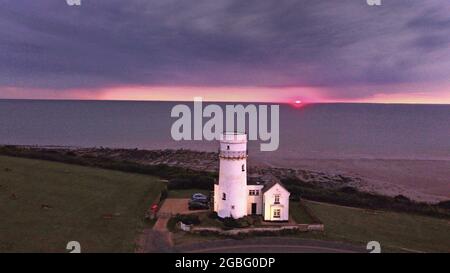 Hunstanton, Großbritannien. August 2021. Am 2. August 2021 geht die Sonne hinter dem alten Leuchtturm von Hunstanton am Ende der Tageslichtstunden in Hunstanton, Norfolk, Großbritannien, unter. Quelle: Paul Marriott/Alamy Live News Stockfoto