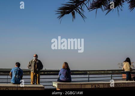 Rosario, Argentinien. August 2021. Ein älterer Mann, der eine Gesichtsmaske trägt, als Vorsichtsmaßnahme gegen die Ausbreitung von Covid 19, während er sich an einem Sonntagnachmittag in Santa Fe auf dem Boardwalk entspannt. (Foto von Patricio Murphy/SOPA Images/Sipa USA) Quelle: SIPA USA/Alamy Live News Stockfoto