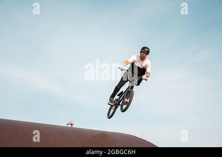 Kazan, Russland - 26. September 2020: Ein junger Fahrer auf einem BMX-Fahrrad macht Tricks in der Luft. BMX Freestyle in einem Skatepark. Stockfoto