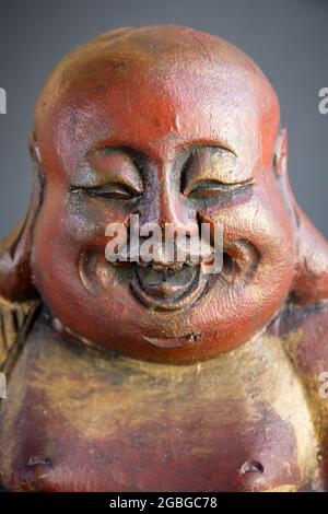 Traditionelle Holzstatue des chinesischen Buddha isoliert auf dunklem Hintergrund Stockfoto