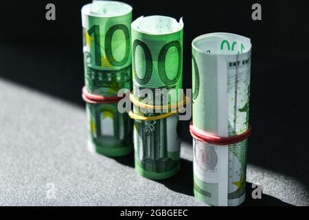 Nahaufnahme der Euro-Geldrolle. Euro-Banknote Set Cash Money - EU-Währung. Gerollt mit Euro-Scheinen aus Gummi. Banknoten sind unterschiedlich aufeinander gestapelt Stockfoto