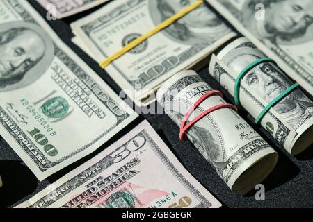 US-Dollar-Bundle-Nahaufnahme isoliert auf Dollar-Hintergrund. Papier Stückelungen von Dollar Cash-Rollen mit Gummibändern. Geschäftsbudget von Vermögen und Stockfoto