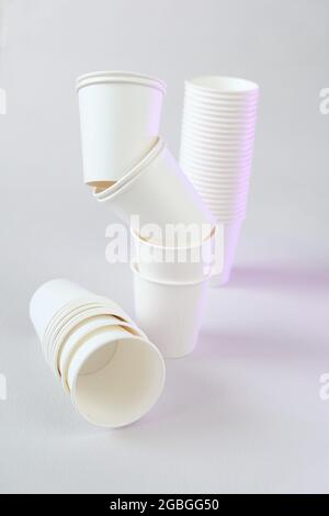 Einweggeschirr ohne Plastik.Zero Waste, Kunststoff freies Konzept. Bio-Becher aus Bambus. Weiße Pappbecher Gruppe auf beigem Hintergrund.Papier Bambus Stockfoto