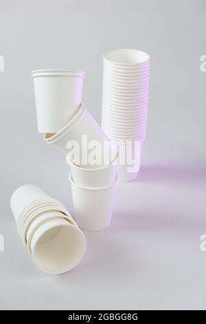 Einweggeschirr ohne Plastik.Zero Waste, Kunststoff freies Konzept. Bio-Becher aus Bambus. Weiße Pappbecher Gruppe auf beigem Hintergrund.Papier Bambus Stockfoto