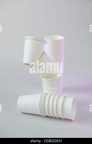 Einweggeschirr ohne Plastik.Zero Waste, Kunststoff freies Konzept. Bio-Becher aus Bambus. Weiße Pappbecher auf beigefarbenem Hintergrund.Pappbecher Set aus Bambus Stockfoto