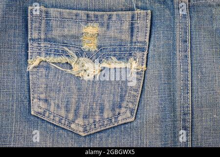 Blaue jean-Textur mit einem Loch und Fäden, die den Hintergrund zeigen Stockfoto