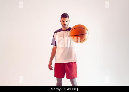 Europäischer Basketballspieler zeigt Ball vor der Kamera Stockfoto