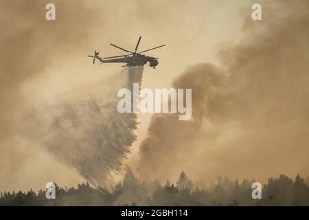 Varibobi, Griechenland. August 2021. Ein Hubschrauber wirft Wasser über einen Waldbrand im Gebiet Varibobi im Norden Athens. Quelle: Angelos Tzortzinis/DPA/Alamy Live News Stockfoto