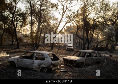 Varibobi, Griechenland. August 2021. Ausgebrannte Fahrzeuge stehen nach einem Waldbrand in der Region Varibobi im Norden Athens vor einem Haus. Quelle: Angelos Tzortzinis/DPA/Alamy Live News Stockfoto