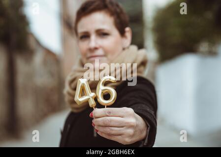 Porträt einer Frau mit Geburtstagskerzen Stockfoto