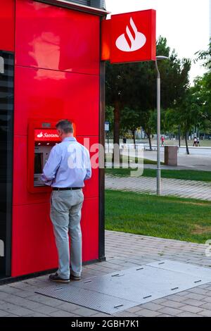 BARCELONA, SPANIEN - 24. Jul 2021: Barcelona, Katalonien, Spanien - 24. Juli 2021: Mann, der Geld von einem Geldautomaten der Bank of Santander in Barce abzieht Stockfoto