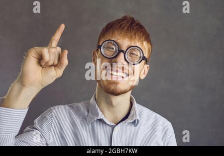 Horizontaler Schuss von bärtig erstaunt schönen Kerl hat aufgeregt Ausdruck, hebt Zeigefinger Stockfoto