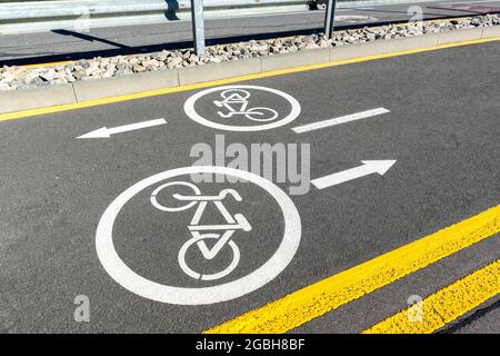 Stadtstraße Asphaltstraße mit abgetrennter zwei-Wege-Richtung Fahrrad Spur Wegweiser Markierung mit weißer Farbe. Moderne umweltfreundliche städtische Pendelverkehr Stockfoto