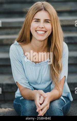 Junge hispanische Frau lächelt vor der Kamera in der Stadt - Fokus auf Gesicht Stockfoto