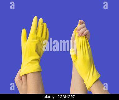 Mit Gummihandschuh, Hand mit Schutzhandschuh aus Latex auf blauem isoliertem Hintergrund Stockfoto