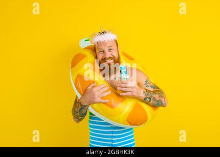 Mann mit Rettungsboje und Prinzessin Krone trinkt einen Fruchtsaft Stockfoto
