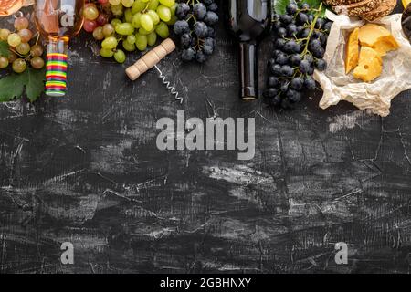 Mediterraner Wein Getränke und Speisen Zutaten langes Webbanner. Verschiedene Rotweine in Flaschen. Wein Trauben Obst gereiften Käse Korkenzieher auf dunkel Stockfoto