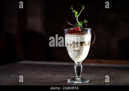 Tiramisu Dessert mit Beeren in einem Glas auf dem Tisch. Stockfoto
