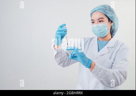 Asiatischer Arzt sucht und Vorbereitung Spritze Impfstoff und Fläschchen für die Injektion an Krankheitspatienten auf weißem Hintergrund. Medizinische Menschen und Krankheit preventio Stockfoto