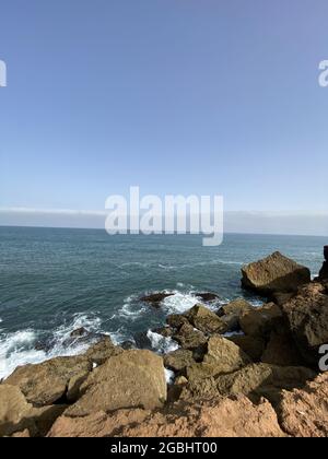 Blick auf die Küste, die im Sommer in Rabat, Marokko, Wasserzermalmen auf Felsen zeigt Stockfoto