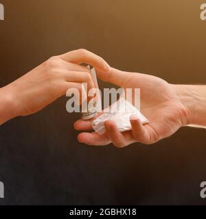 Addict kauft eine Dosis Drogen, weißes Pulver in einem Beutel auf schwarzem Hintergrund. Neu Stockfoto