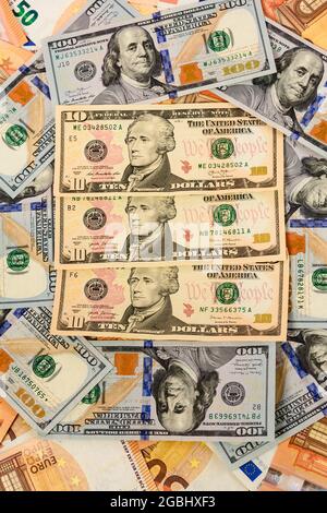 Viele Dollar und Euro, Textur des Geldes, der Vorteil des Euro gegenüber dem Dollar. Neu Stockfoto