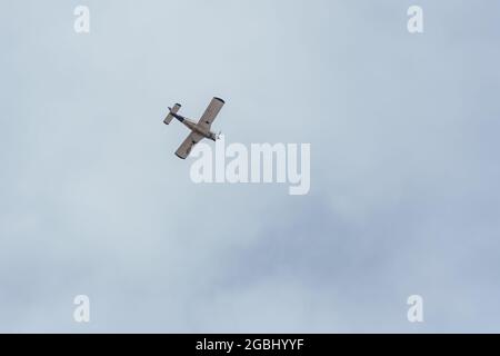 Eine gegenläufige Aufnahme des Bodens eines Propellerflugzeugs, das durch den Himmel fliegt Stockfoto