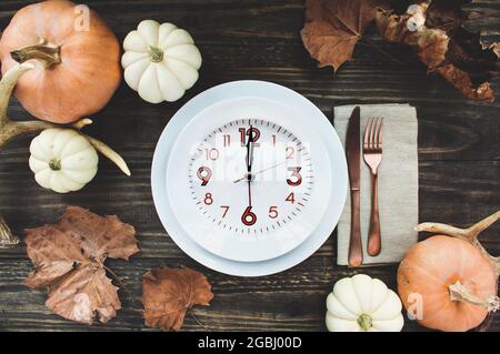 Intermittierendes Fastenkonzept mit Festtagsausstattung mit Teller, Serviette, Geweih und Besteck an einem mit Thanksgiving-Tag dekorierten Tisch-Flatlay. Stockfoto