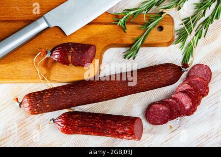 Rohe geräucherte Salami mit frischem Rosmarin Stockfoto